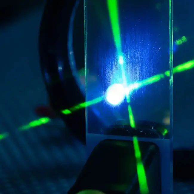 Laser beams cross in front of dark background